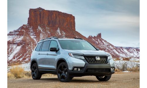 2021 Honda Passport exterior shot parked in a desert mountain setting with Lunar Silver Metallic paint color