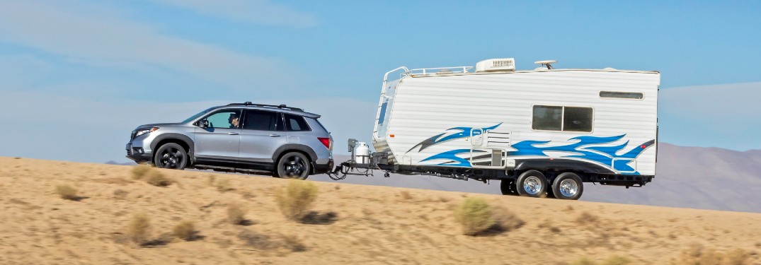 2021 Honda Passport with Towing Hitch exterior side shot towing an RV on a desert road