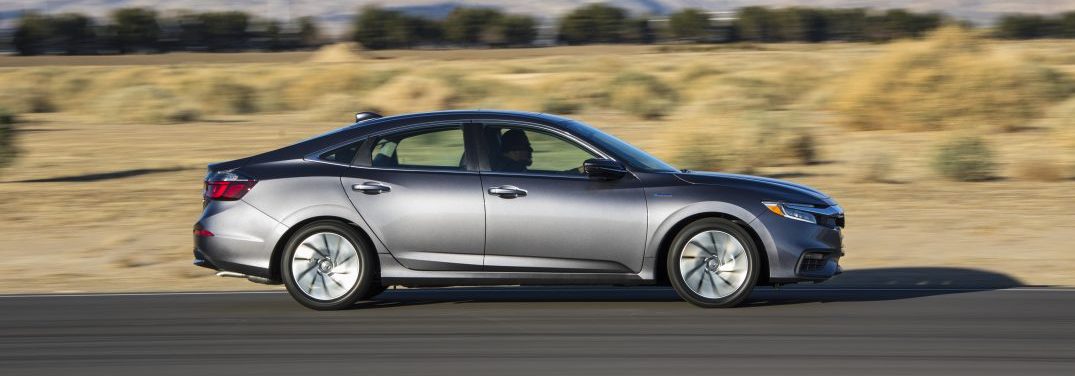 2019 Honda Insight side profile driving on a highway by an open field