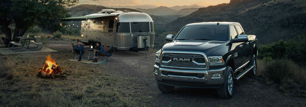 Front exterior view of a black 2018 Ram 2500 parked next to an Airstream trailer