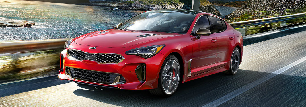 Red 2018 Kia Stinger driving on waterfront road
