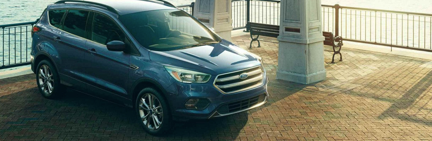 Blue 2018 Ford Escape Parked in front of a fence near the water