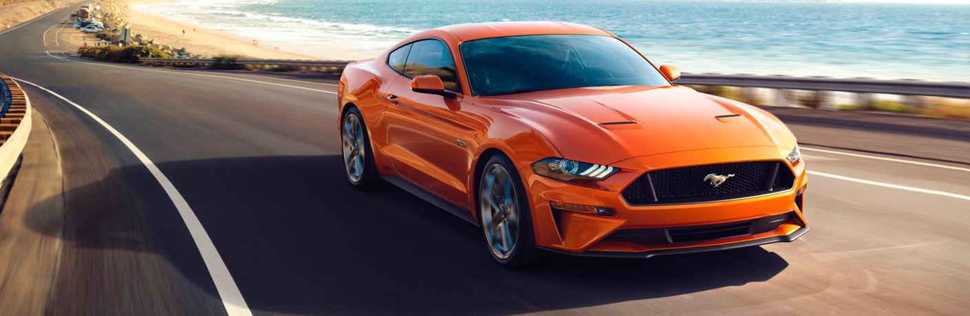 Orange 2018 Ford Mustang driving on the highway