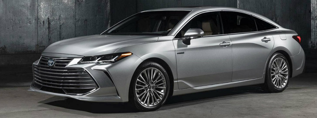 Exterior view of a silver 2019 Toyota Avalon parked in a dimly lit warehouse