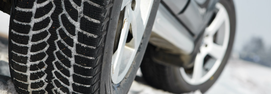 close up of car tires driving through snow