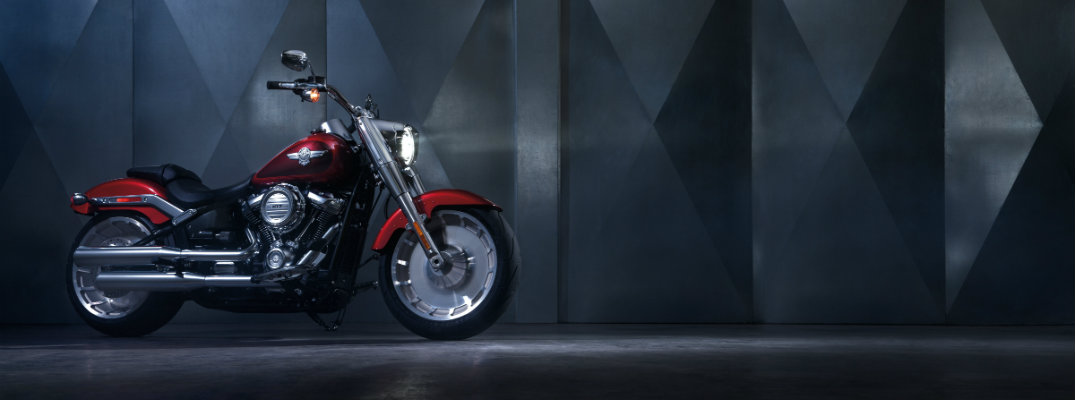 Red 2018 Harley-Davidson FAT BOY motorcycle with a grey industrial background