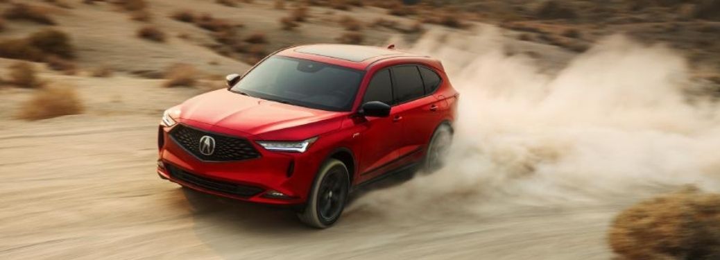 Red 2022 Acura MDX cruising through sand