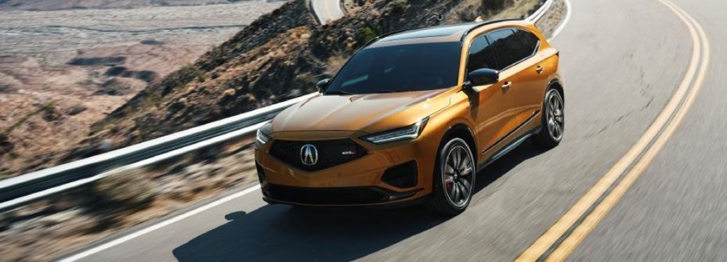 Yellow 2022 Acura MDX Type S cruising through the road