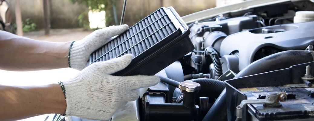 A mechanic with a car filter on his hand