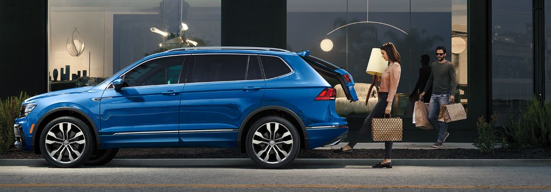 A woman putting luggage inside of a 2020 Volkswagen Tiguan