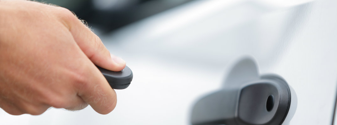 Hand unlocking a door with a key FOB