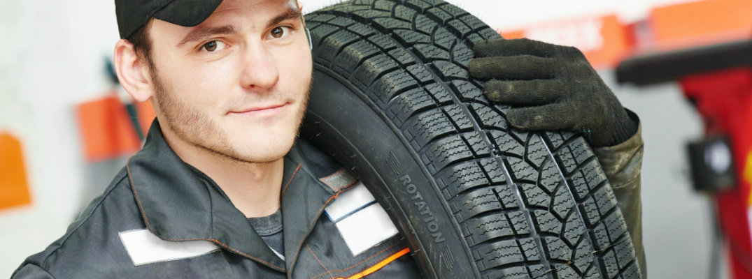 Service technician carrying a tire