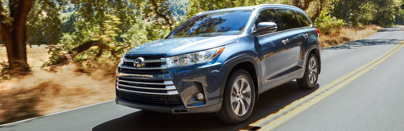 Blue 2018 Toyota Highlander driving down the highway during the day