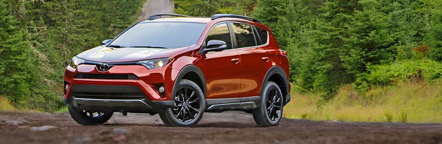 Red 2018 Toyota Rav4 parked in the woods