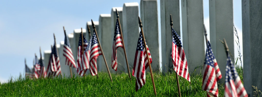 American flags decorating gravestones in Arlington National Cemetery to commemorate Memorial Day
