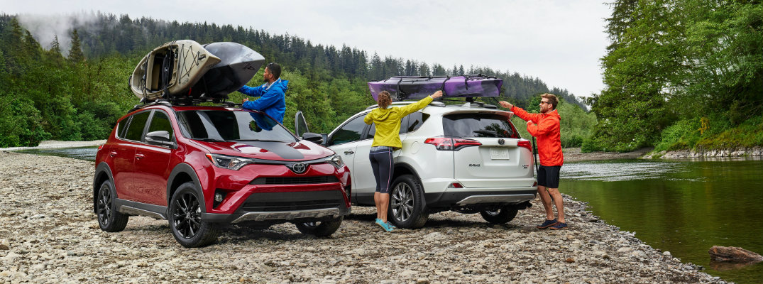 Red and white Toyota RAV4 parked on riverfront ground