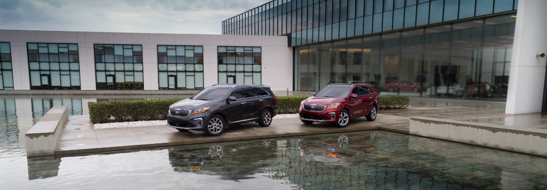 gray and red kia sorento vehicles parked by water
