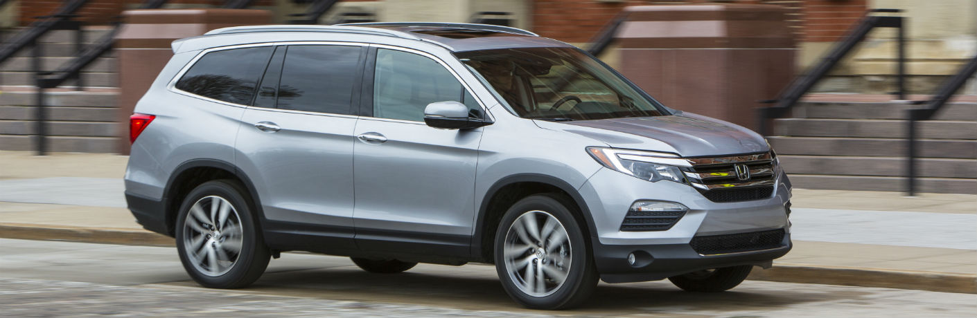 Exterior view of a silver 2018 Honda Pilot parked on a street