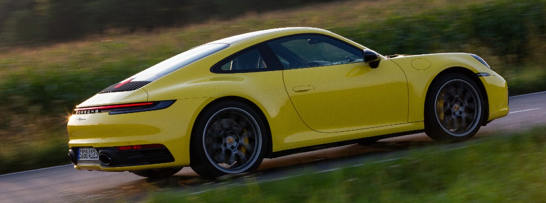 A right profile photo of a Porsche 911 on the road.