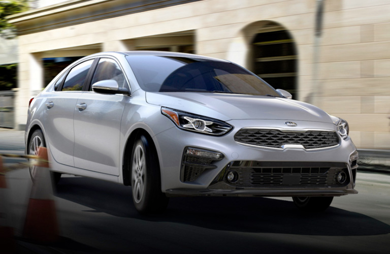 2020 Kia Forte exterior front fascia passenger side on road with blurred brick building
