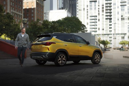 2021 Kia Seltos exterior rear fascia passenger side in city with man walking behind it