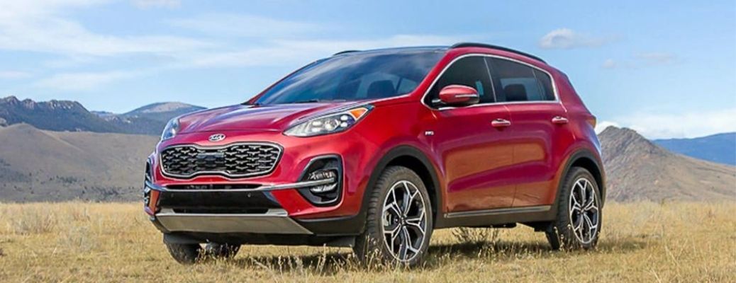 2022 Kia Sportage parked over a grass land with mountains in background