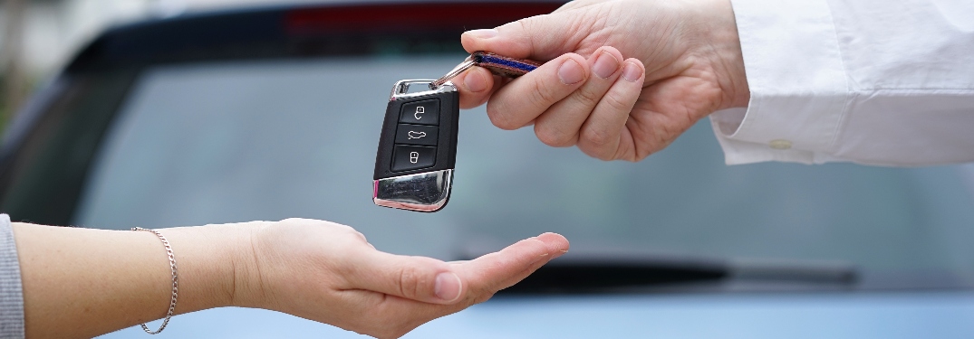 Person from Dealership Handing Keys to Customer