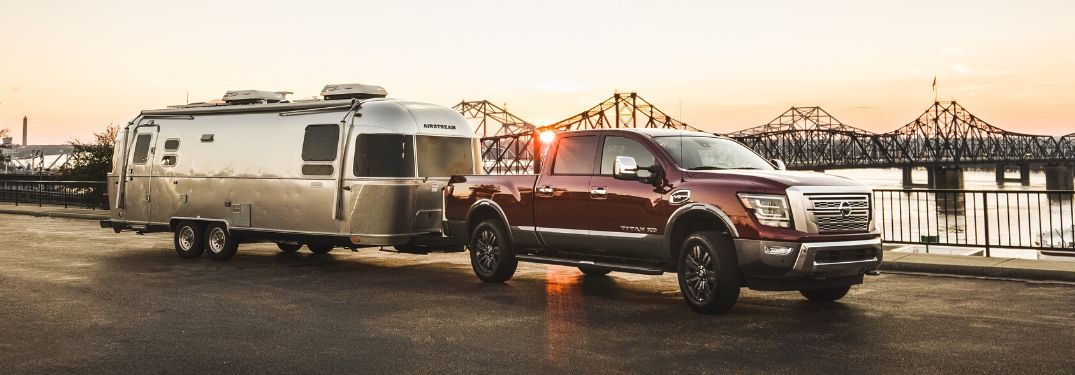 Red 2020 Nissan Titan Towing a Trailer at Sunset