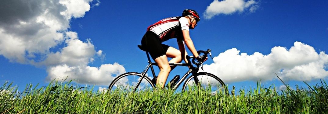 Man Biking on a Grassy Trail