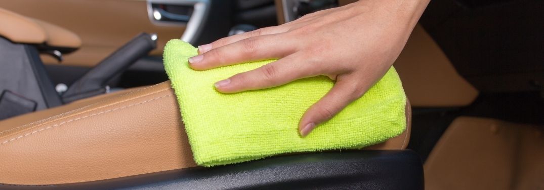 Woman Cleaning Leather Car Interior with Yellow Cloth