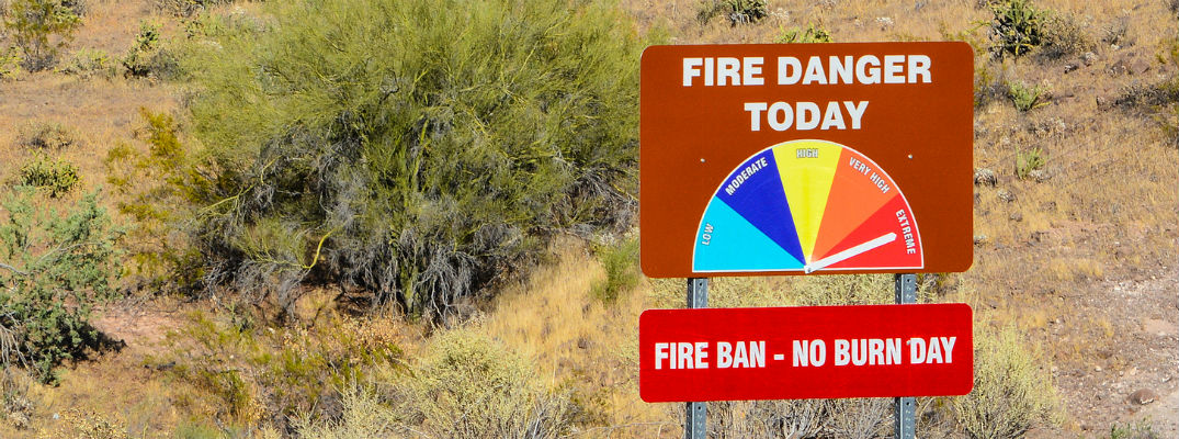 Fire danger sign with colored chart and arrow pointing to red