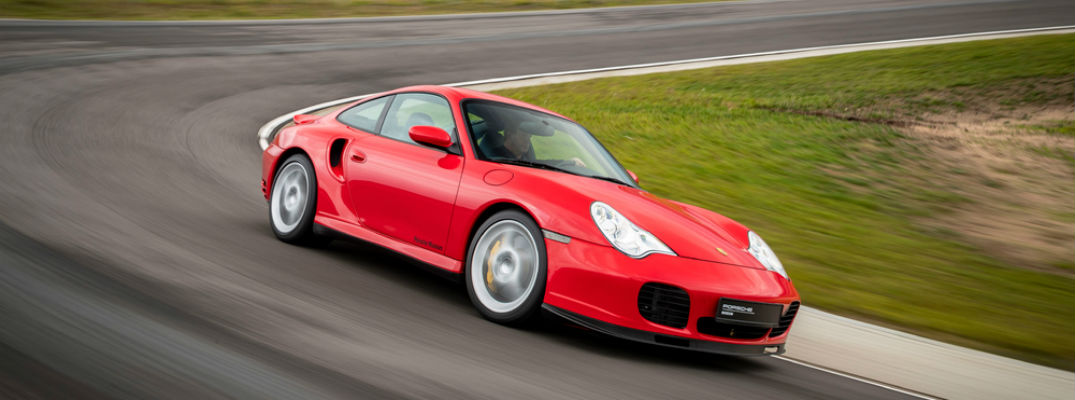 Red historic Porsche 911 driving on track