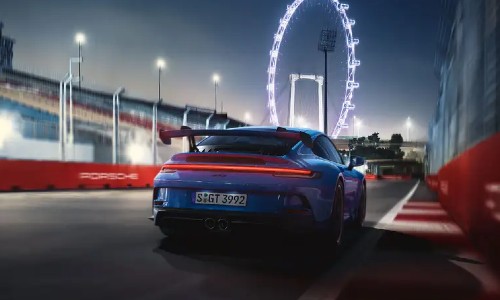 Rear view of blue 2021 Porsche 911 GT3 in front of ferris wheel