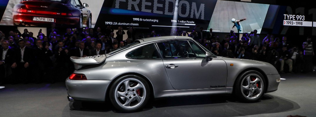 A right profile photo of a Porsche vehicle at an auto show.