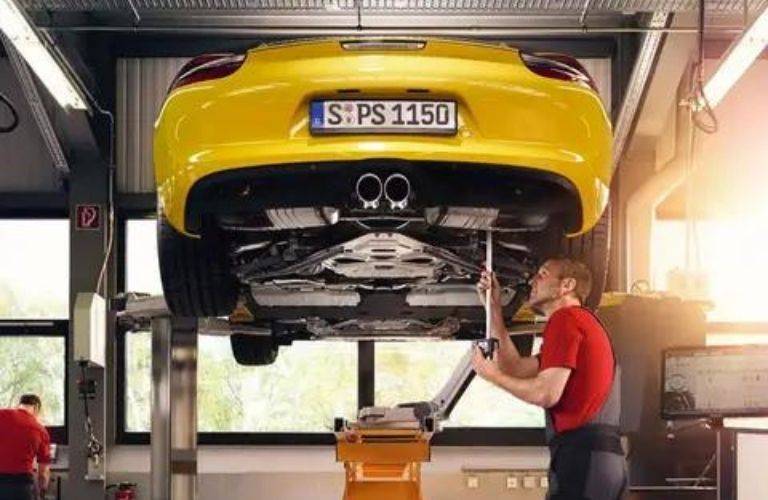 Porsche professional servicing a car at the service center