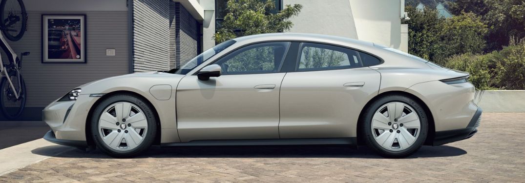 Side view of a 2022 Porsche Taycan parked near a house.