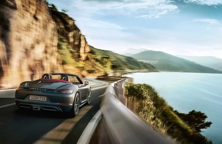 2024 Porsche 718 Cayman driving beside the beach