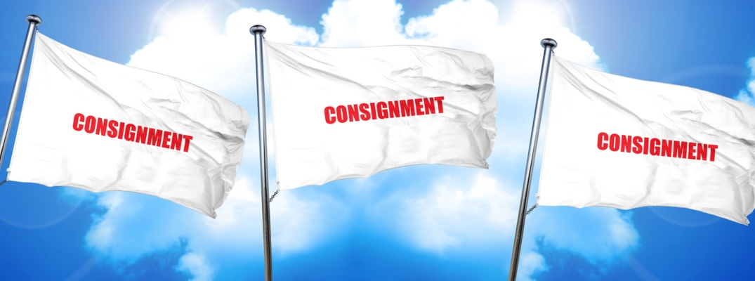 Image of three white flags blowing in the wind with the word "consignment" in red text