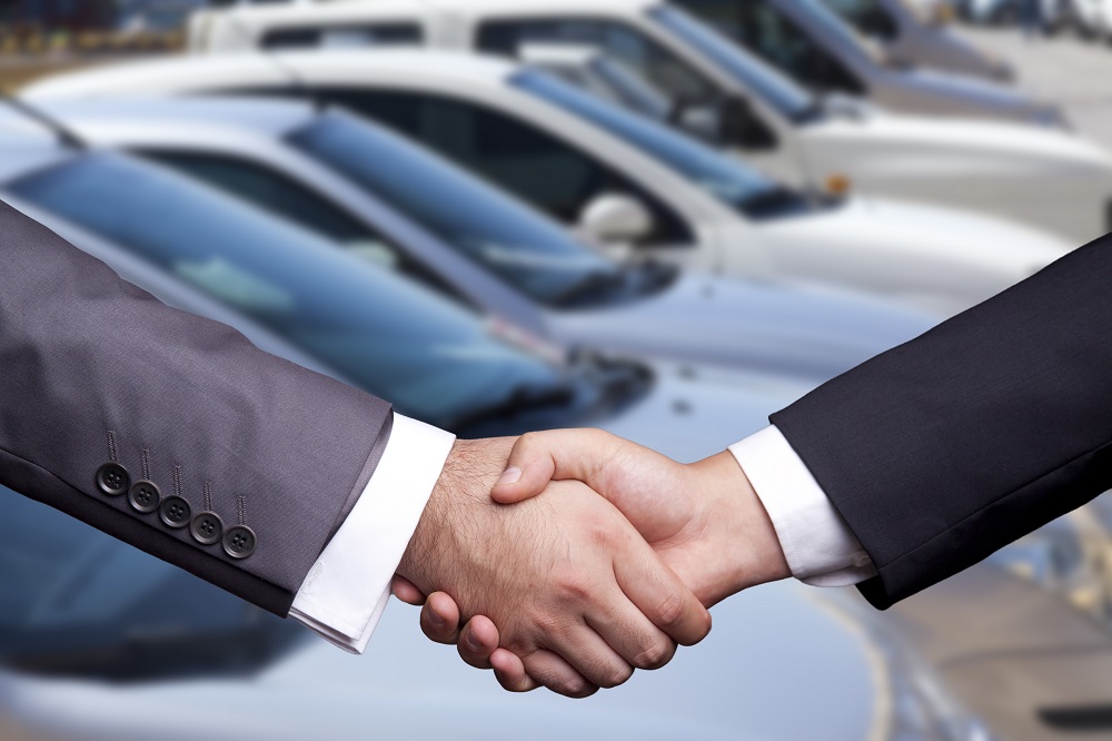 Handshake in Front of Cars