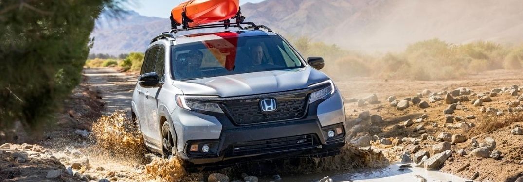 Silver 2020 Honda Passport Crossing a River with Orange Kayak on Top