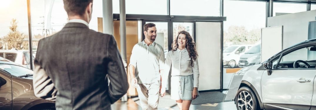 Young Couple Walking into a Car Dealership