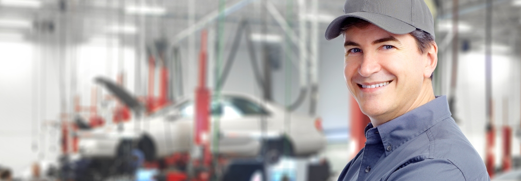 Car mechanic with cars in the background