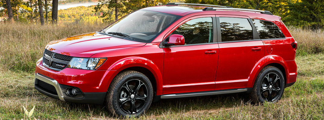 Profile shot of red 2018 Dodge Journey parked in grassy field