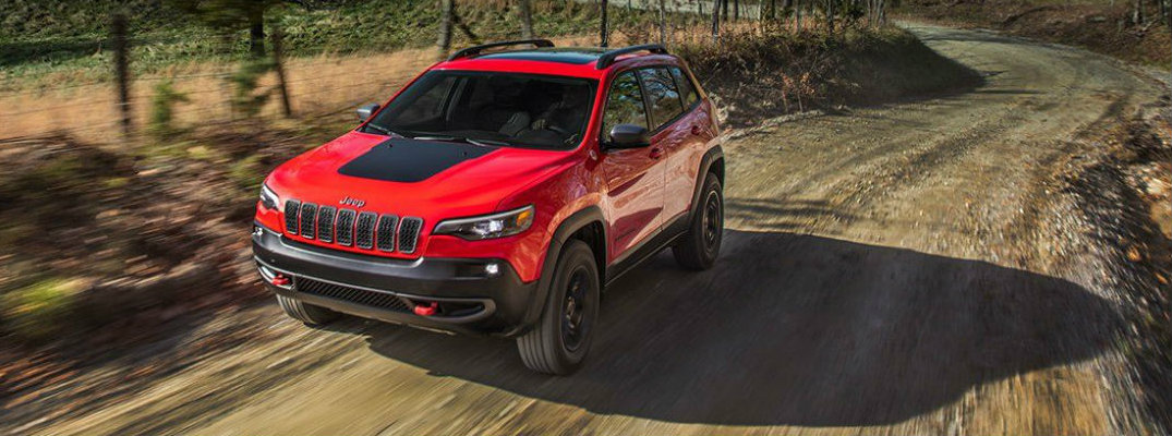 Red Jeep Cherokee driving on country trail