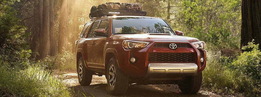 Red 2018 Toyota 4Runner hauling cargo through wooded area