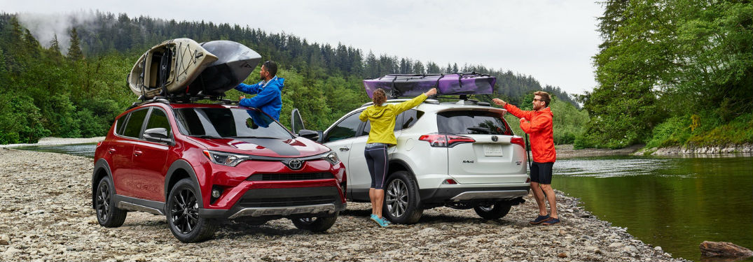 Front exterior view of a red 2018 Toyota Rav4 Hybrid and a rear exterior view of a white 2018 Toyota Rav4 Hybrid