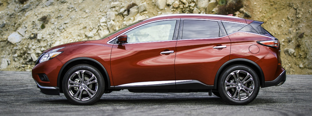 2018 Nissan Murano exterior side shot cayenne red parked next to a rocky mountain hill background