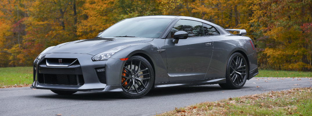 2018 Nissan GT-R roadster exterior super silver color parked on a curving road next to fall trees and leaves