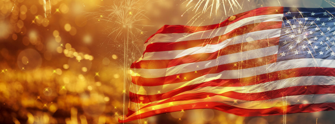 fireworks celebration in the sky for Independence Day happening in front of a waving American flag