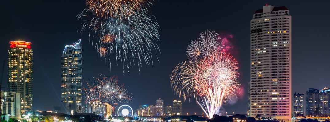 a city skyline at night lit up with lights and exploding fireworks in the sky for a new year's eve celebration